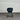Dark blue chair against a corrugated metal wall.