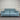 Blue power sofa with black metal legs, against a striped wall