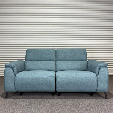 Blue power sofa with black metal legs, against a striped wall