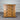 oat Wooden dresser with four drawers against a corrugated metal background