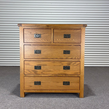 oat Wooden dresser with four drawers against a corrugated metal background