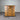 Wooden dresser with four drawers against a corrugated metal wall.