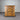 Wooden dresser with four drawers against a corrugated metal wall.