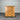 Wooden dresser with multiple drawers against a corrugated metal wall.