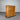 Wooden dresser with multiple drawers against a corrugated metal background