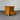 Wooden nightstand with two drawers, one open, against a corrugated metal background.