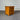 Wooden nightstand with three drawers against a corrugated metal background