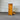 Pine wood tallboy with a drawer open against a corrugated metal wall.