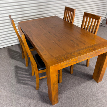Wooden dining table with four matching chairs on a gray floor. wanaka collection