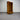 Wooden bookshelf with a drawer against a corrugated metal wall. wanaka collection