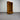 Wooden bookshelf with a drawer against a corrugated metal wall. wanaka collection