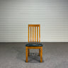 Wooden chair with a black seat against a corrugated metal wall - Wanaka Collection.