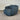 Blue swivel chair on a gray floor with a corrugated metal wall background