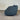 Blue armchair on a gray floor with a corrugated metal wall in the background