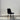 Modern black upholstered dining chair with metal legs, angled perspective