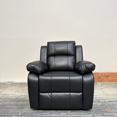 Black leather manual recliner chair photographed front on in a modern lounge setting