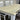 Wooden table with white chairs on a dark floor