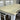 Wooden table with white chairs on a gray surface