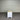White bench with beige top against a corrugated metal wall.