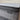 Close-up of Workhorse LUX mattress corner showing grey textured fabric with herringbone pattern, black piping, and Workhorse LUX label, highlighting stitching details.