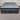 Front top view of Workhorse LUX mattress with matching base showing grey quilted top, dark upholstered base and Hotel Mattress Co branding against corrugated backdrop