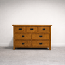 Wooden dresser with six drawers on a plain background
