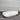 White rectangular planter on a gray surface with a striped wall background