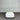 White rectangular object on a gray floor with a corrugated metal wall in the background