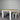 Dining table with two benches against a corrugated metal wall.