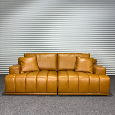 Tan Brown leather sofa against a metallic shutter background