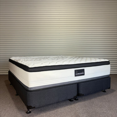 Mattress with a brand label on a striped wall background