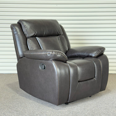 Gray leather look recliner chair against a corrugated metal background
