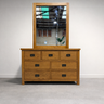 Wooden dresser with mirror on a plain background