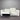 White sectional sofa against a metallic wall.