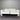 White sectional sofa against a metallic wall.