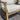 Wooden chair with light gray cushions on a gray floor.