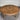 Round wooden table with a concentric circle design on a gray floor.
