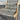 Wicker chair with gray woven seat and backrest on a gray floor.