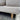 Gray textured sofa with wooden leg on a concrete floor
