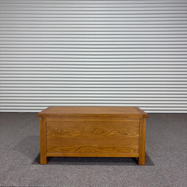 Wooden chest on a gray floor with a corrugated metal wall in the background