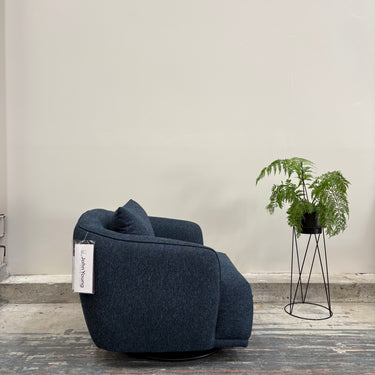 Blue armchair with a plant on a light gray background