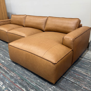 Brown leather sectional sofa on a gray carpet