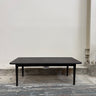 Black rectangular table against a plain white wall.