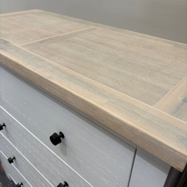 Wooden countertop on a white cabinet with black handles