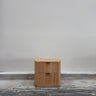 Wooden cabinet with two drawers on a concrete floor against a gray wall