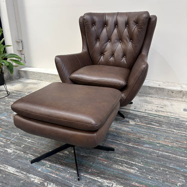 Brown leather armchair with ottoman on a wooden floor