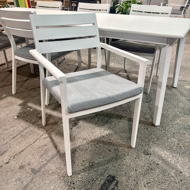 Mantra outdoor dining table and six chairs shown from angle view in matte white anodised aluminium