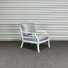 Chair with gray cushion against a corrugated metal wall.