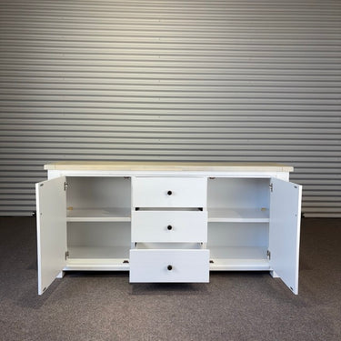 White storage unit with open doors and drawers against a corrugated metal wall. kinloch collection