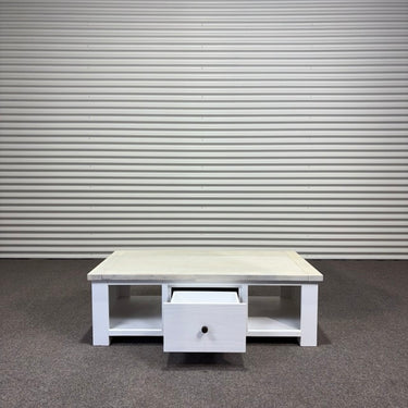 White wooden coffee table with a drawer against a metallic shutter background